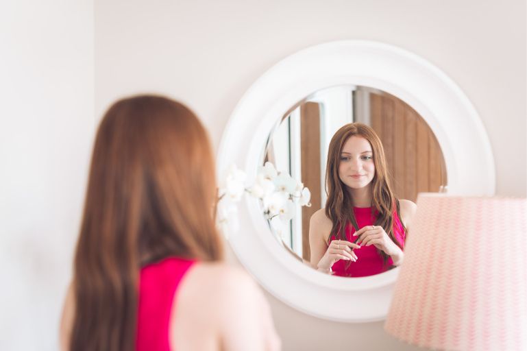 Teen girl looking in mirror